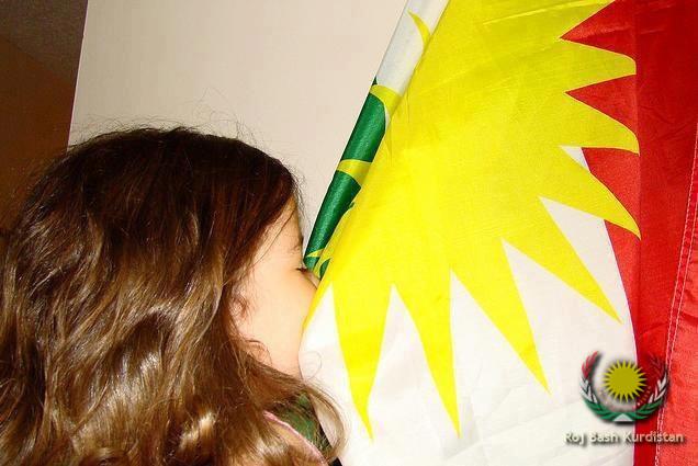 Kurdish kid kissing Kurdistan flag