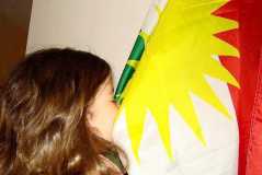 Kurdish kid kissing Kurdistan flag